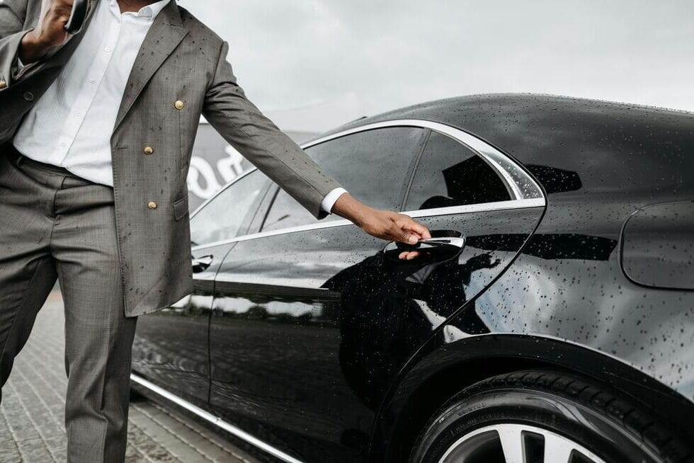 Professional chauffeur opening door of Starling Executive Travel vehicle